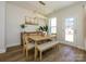 The dining area features stylish light fixture, a wooden table with bench, and view of the backyard at 165 Halite Ln, Waxhaw, NC 28173