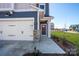 Close up view of this beautiful home's entrance, featuring a two car garage, stone accents, and a well manicured lawn at 165 Halite Ln, Waxhaw, NC 28173