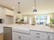 Stylish kitchen with a farmhouse sink, stainless steel dishwasher, and a view into the living area at 165 Halite Ln, Waxhaw, NC 28173
