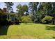 Lush backyard with green lawn, mature trees, and shrubs, providing a serene outdoor space and private ambiance at 829 Rawlinson Rd, Rock Hill, SC 29732