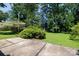 Landscaped backyard featuring a concrete patio area and lush green lawn surrounded by mature trees and shrubs at 829 Rawlinson Rd, Rock Hill, SC 29732