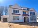 Two-story home with white siding, a dark roof, black-framed windows, and a two-car garage at 1015 Kendall Dr # 4, Wesley Chapel, NC 28173