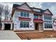 Two-story house under construction with Tyvek wrap and new window installation, showing framing and progress at 1015 Kendall Dr # 4, Wesley Chapel, NC 28173