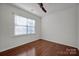 Simple bedroom with hardwood floors and large window with blinds at 10436 Paisley Abbey Ln, Charlotte, NC 28273