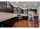 Modern kitchen with dark cabinetry, granite countertops, and stainless steel appliances at 10436 Paisley Abbey Ln, Charlotte, NC 28273