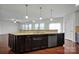 Large kitchen island with granite countertop and dark cabinets at 10436 Paisley Abbey Ln, Charlotte, NC 28273