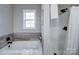 Bathroom featuring a soaking tub, shower, and wood-look tile at 131 Nantz Ave, Mount Holly, NC 28120