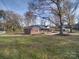 Side view of the brick ranch house showcasing its landscaping at 131 Nantz Ave, Mount Holly, NC 28120