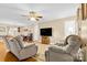 Spacious living room featuring hardwood floors, two recliners, and a large TV at 135 Rumple Hill Dr, Statesville, NC 28677