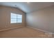 Cozy bedroom with neutral carpet, vaulted ceiling, and a window offering natural light at 138 Gray Willow St, Mooresville, NC 28117