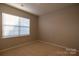 Comfortable bedroom with neutral walls and carpet and a large window providing ample natural light at 138 Gray Willow St, Mooresville, NC 28117