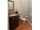 Updated bathroom with dark vanity, tile backsplash, and wood flooring at 158 White Rd, Wadesboro, NC 28170