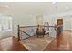 Upstairs hallway with comfortable seating area and hardwood floors at 19100 Mary Ardrey Cir, Cornelius, NC 28031