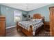 Bedroom with wood flooring, a wooden bed frame, and a view of the backyard at 303 Knox St, Clover, SC 29710