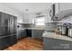 Modern kitchen with gray cabinets, stainless steel appliances, and tin backsplash at 303 Knox St, Clover, SC 29710