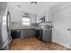 Modern kitchen with gray cabinets, stainless steel appliances, and tin backsplash at 303 Knox St, Clover, SC 29710