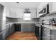 Modern kitchen with gray cabinets, stainless steel appliances, and tin backsplash at 303 Knox St, Clover, SC 29710