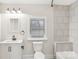 Bathroom with white vanity, tiled shower, and window at 309 S Ransom St, Gastonia, NC 28052