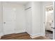 Hallway with wood flooring, linen closet, and doorway to a bright bathroom at 309 S Ransom St, Gastonia, NC 28052