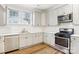 Modern kitchen with gray cabinets, stainless steel appliances, and white tile backsplash at 309 S Ransom St, Gastonia, NC 28052