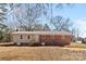 Exterior view of a brick and siding house with a metal roof and bare backyard at 440 Providence Rd, Lancaster, SC 29720