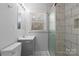 Bathroom featuring marble-look tiling in the shower, gray vanity, and a window providing natural light at 440 Providence Rd, Lancaster, SC 29720