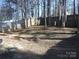 Fenced backyard with mature trees and small patio area at 8027 Bristle Ln, Charlotte, NC 28214