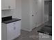 View of kitchen features, white cabinets with modern hardware, and black countertops at 8027 Bristle Ln, Charlotte, NC 28214