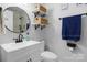 Simple bathroom with white vanity, floating shelves, and a large mirror at 8478 Rocky River Rd, Harrisburg, NC 28075