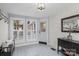 Light-filled entryway with tiled floors, a bench, and whitewashed brick walls at 8478 Rocky River Rd, Harrisburg, NC 28075