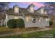 Two-story home with white brick exterior, dormer windows, and a front porch at 8478 Rocky River Rd, Harrisburg, NC 28075