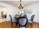 Bright dining room with a dark wood table and four gray chairs, hardwood floors, and a chandelier at 2610 Tattersall Dr, Charlotte, NC 28210