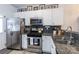 Modern kitchen with white cabinets, granite countertops, and stainless steel appliances at 112 Canina Ln, Indian Trail, NC 28079