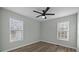 Bedroom with ceiling fan, two windows with blinds, and wood-look flooring at 116 E Maryland Ave, Bessemer City, NC 28016