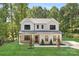 Two-story house with gray siding, a covered porch, and a landscaped lawn at 13114 Blacksmith Ct, Matthews, NC 28105