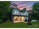 Two-story house with gray siding, a covered porch, and landscaping at dusk at 13114 Blacksmith Ct, Matthews, NC 28105