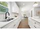 White kitchen with black accents, marble backsplash, and stainless steel sink at 13114 Blacksmith Ct, Matthews, NC 28105