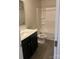 Clean bathroom with dark vanity, a white bathtub, and wood-look flooring at 1608 Cole St, Gastonia, NC 28054