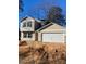 Two-story house with beige siding, a white garage door, and a partially landscaped yard at 1608 Cole St, Gastonia, NC 28054