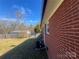 Exterior view of a brick home with a well-maintained yard and an air conditioning unit at 1907 Steele St, Monroe, NC 28110