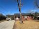 Lovely one-story brick house featuring a covered carport and a well-maintained lawn area at 1907 Steele St, Monroe, NC 28110