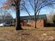 Brick home with a welcoming front porch and a well-maintained yard and mature trees at 1907 Steele St, Monroe, NC 28110