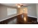 Bright living room featuring hardwood floors, a ceiling fan, large windows, and neutral paint color at 1907 Steele St, Monroe, NC 28110