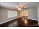 Inviting living room with dark hardwood floors, a ceiling fan, and natural light from large windows at 1907 Steele St, Monroe, NC 28110