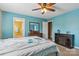 Comfortable main bedroom with turquoise walls, a ceiling fan, and a cozy fireplace at 1976 Mcilwain Rd, Lancaster, SC 29720