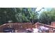 A wooden deck is furnished with chairs and a table, overlooking a lush green yard with mature trees at 327 Coxe Ave, Charlotte, NC 28208