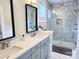 Bright bathroom featuring a double sink vanity and glass-enclosed shower with marble-look tile surround at 327 Coxe Ave, Charlotte, NC 28208