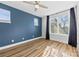Bright bedroom with three large windows, hardwood floors, and a ceiling fan at 327 Coxe Ave, Charlotte, NC 28208