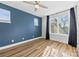 Spacious bedroom with hardwood floors, ceiling fan, and blue accent wall at 327 Coxe Ave, Charlotte, NC 28208