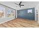 Bright bedroom featuring light hardwood floors and a blue accent wall at 327 Coxe Ave, Charlotte, NC 28208